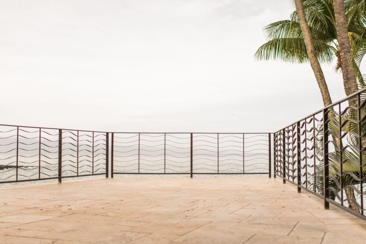 Empty balcony with metal railing overlooking a foggy view.