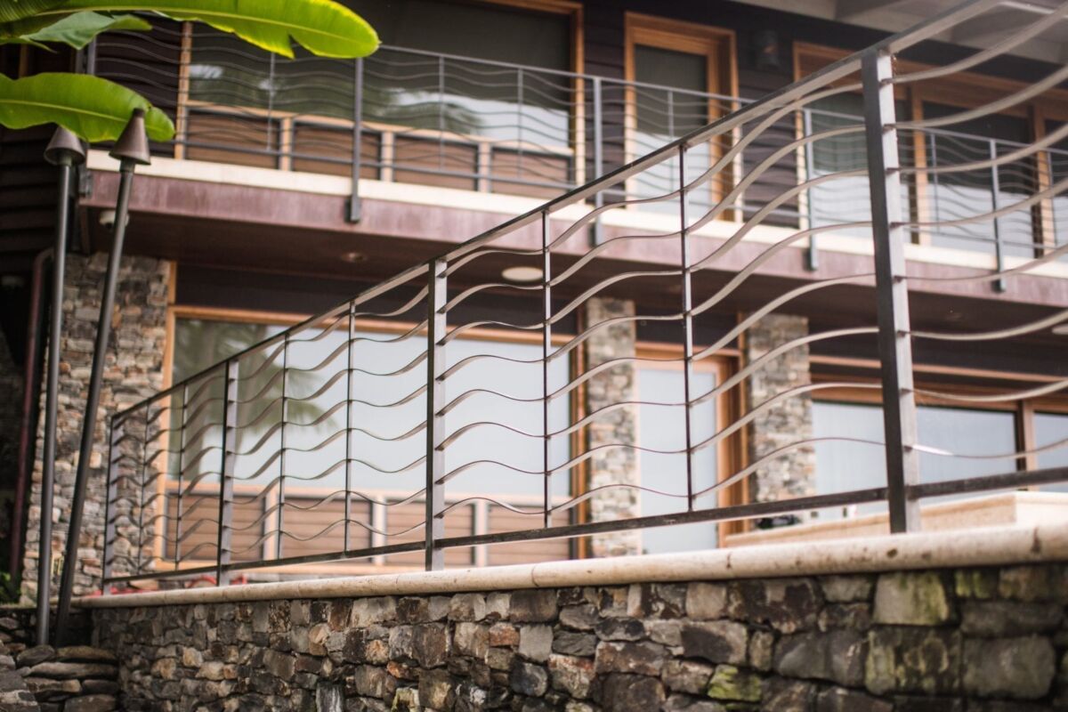 Modern staircase with artistic metal railing and wooden steps.