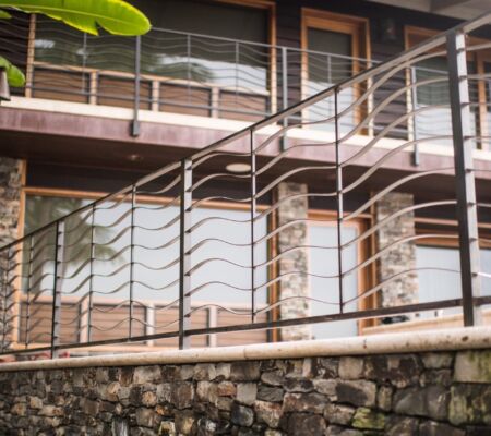 Modern staircase with artistic metal railing and wooden steps.
