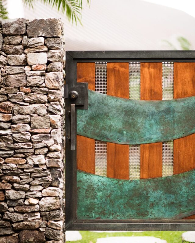 Close-up of a rustic wooden door with metal accents beside a stone wall.