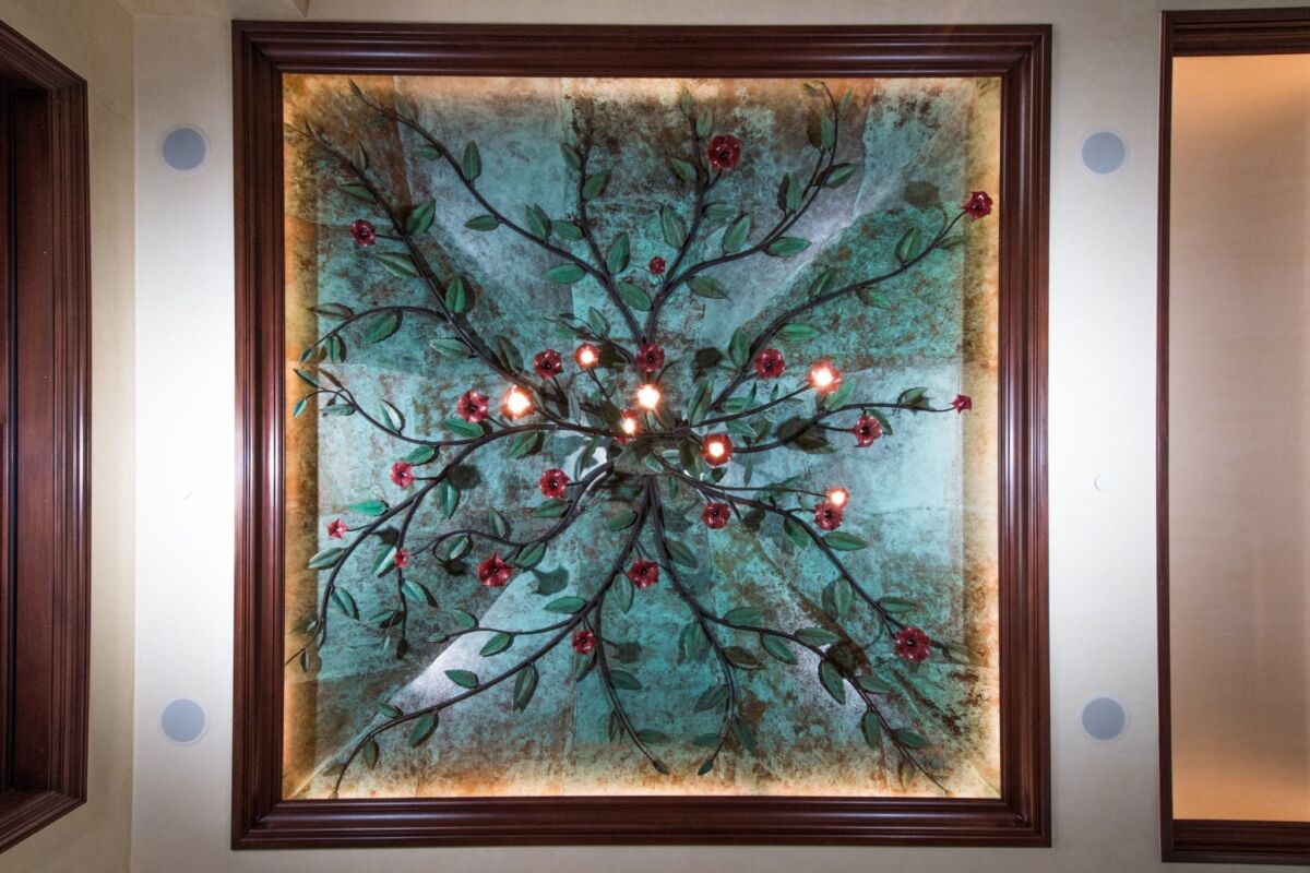Ceiling light fixture with multiple bulbs and floral decor.