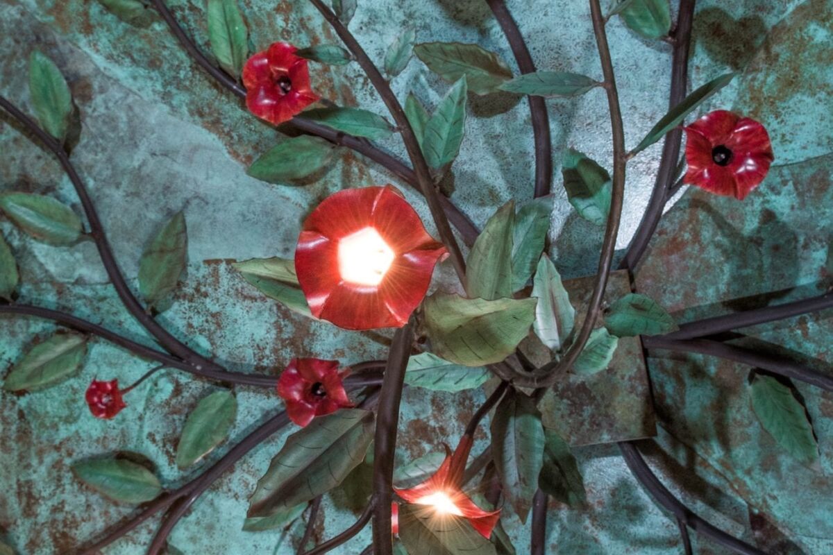 Decorative ceiling lights with red flower-shaped covers and green leaves.