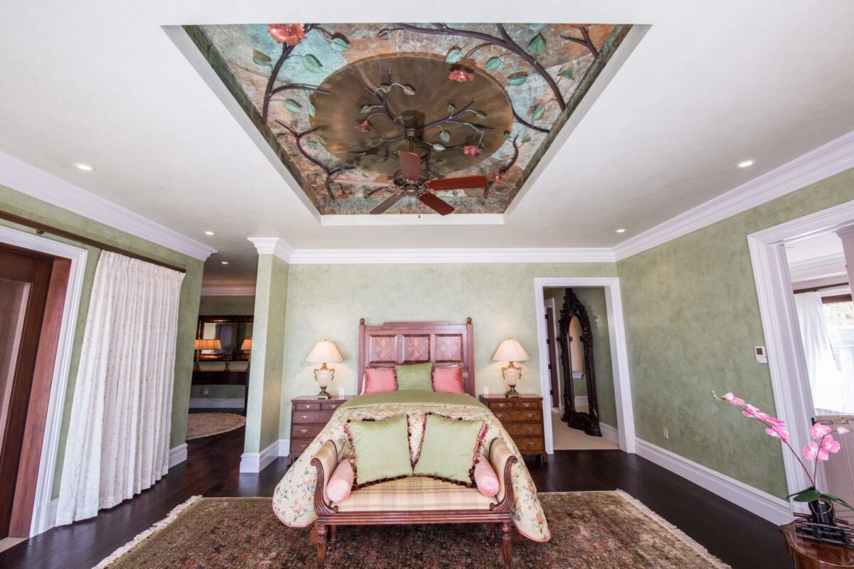 Elegant bedroom with ornate ceiling and classic furniture.