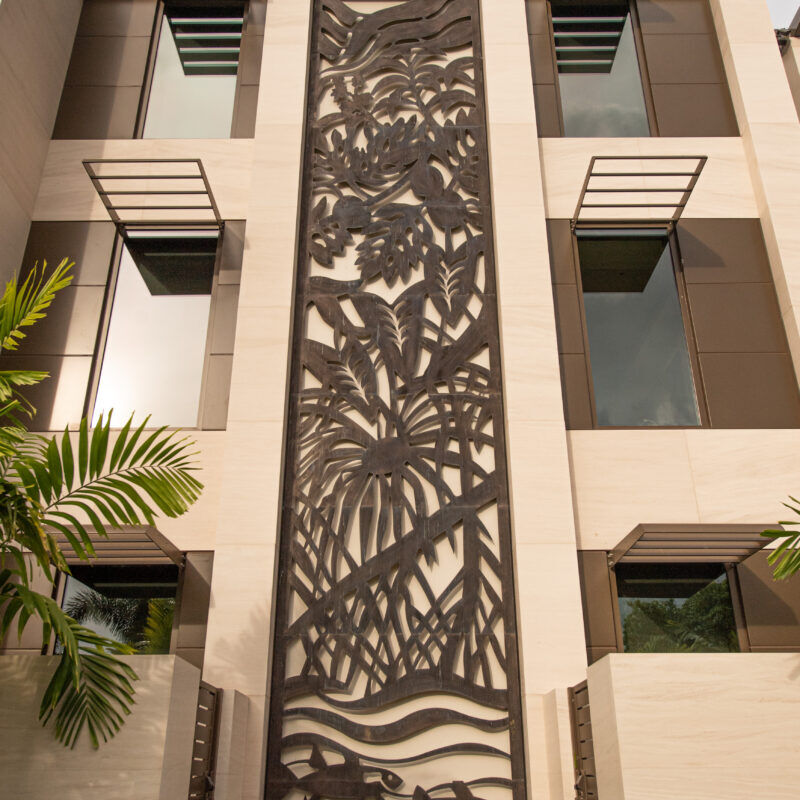 Tall building with intricate palm tree shadows on its facade.