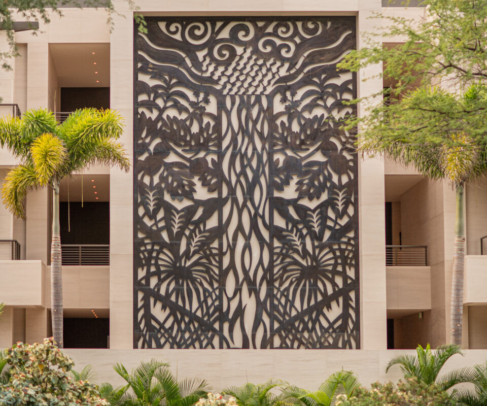 Intricate black and white tree mural on a building facade.