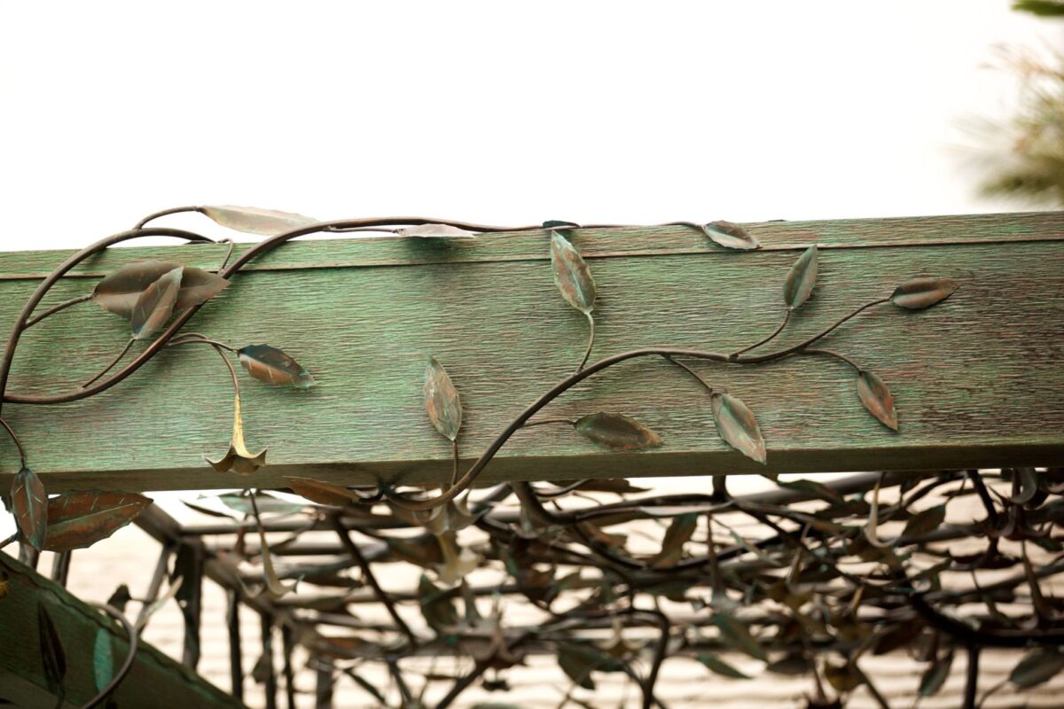 Close-up of a green wooden frame with rusty wire mesh.