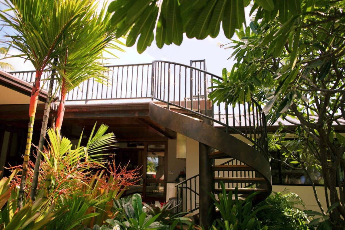 Modern outdoor staircase surrounded by greenery leading to an elevated platform.