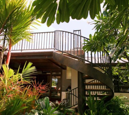 Modern outdoor staircase surrounded by greenery leading to an elevated platform.
