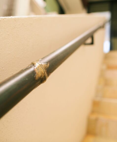 Metal stair handrail showing soldered joint