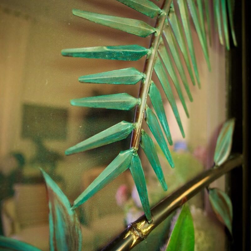 Close-up of a green plant branch with pointed leaves.