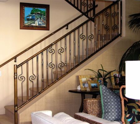 Elegant staircase with wrought iron railing and cozy seating area.