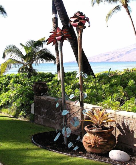 A tropical garden with palm trees and a view of the ocean.
