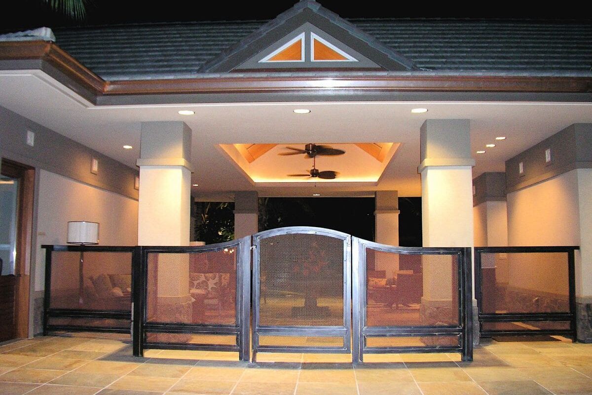 Modern outdoor patio with ceiling fan and safety gate at night.