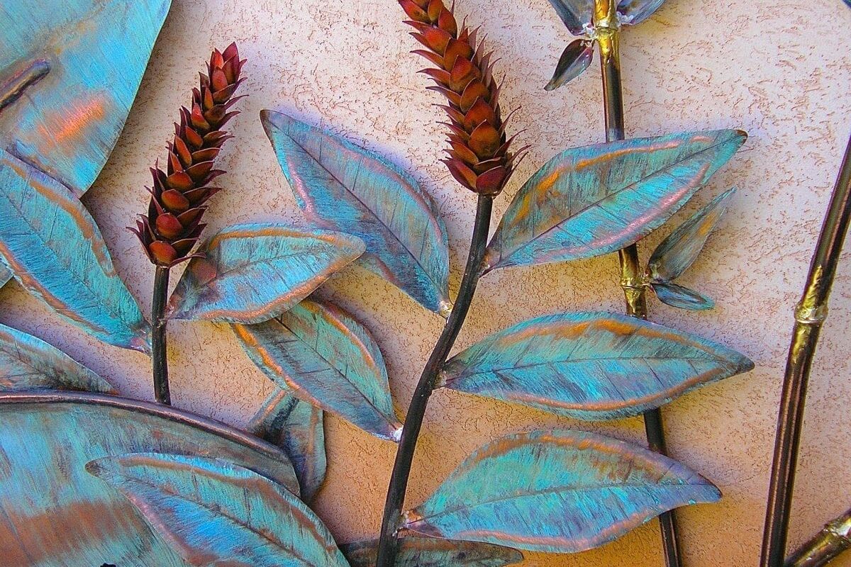 Close-up of a colorful metal leaf and flower wall sculpture.
