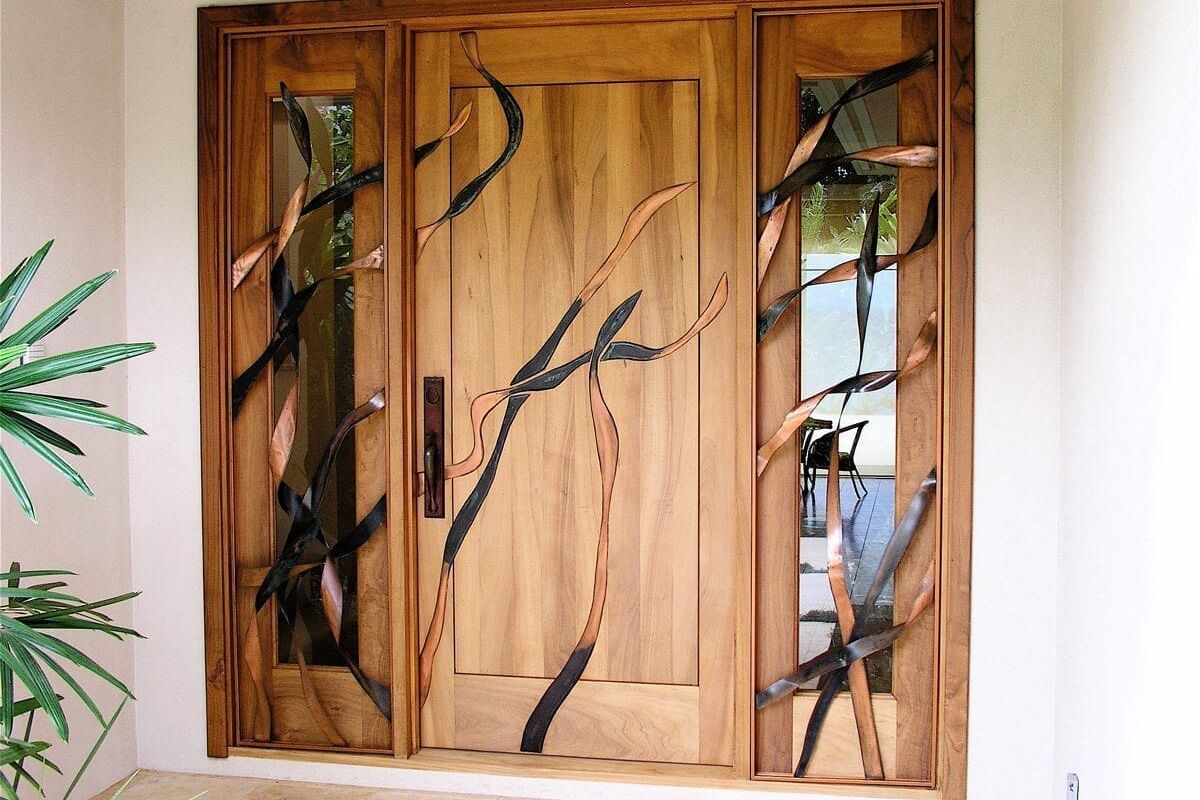 Wooden door with artistic glass panel featuring tree branch design.