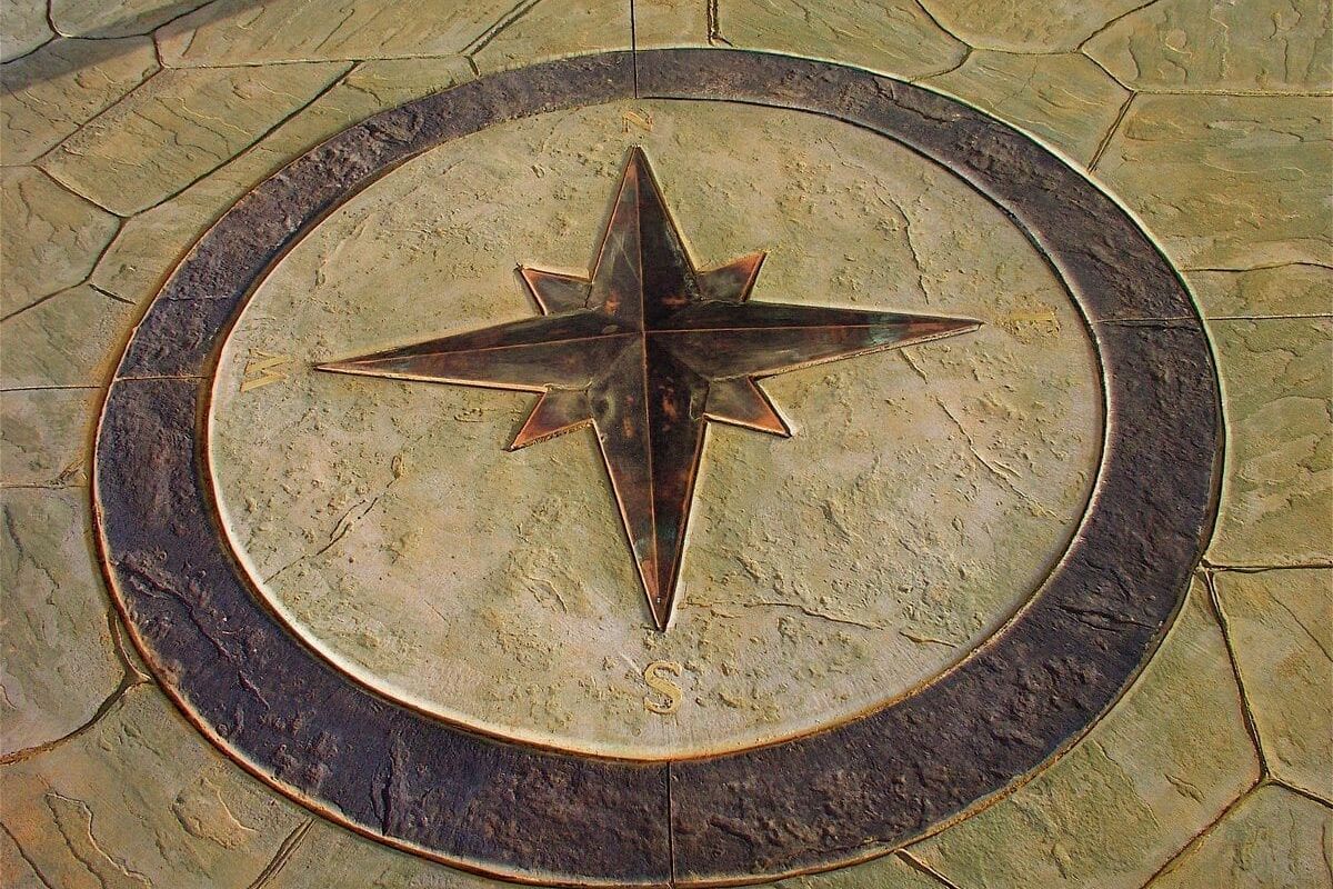 A stone compass rose embedded in a paved surface.