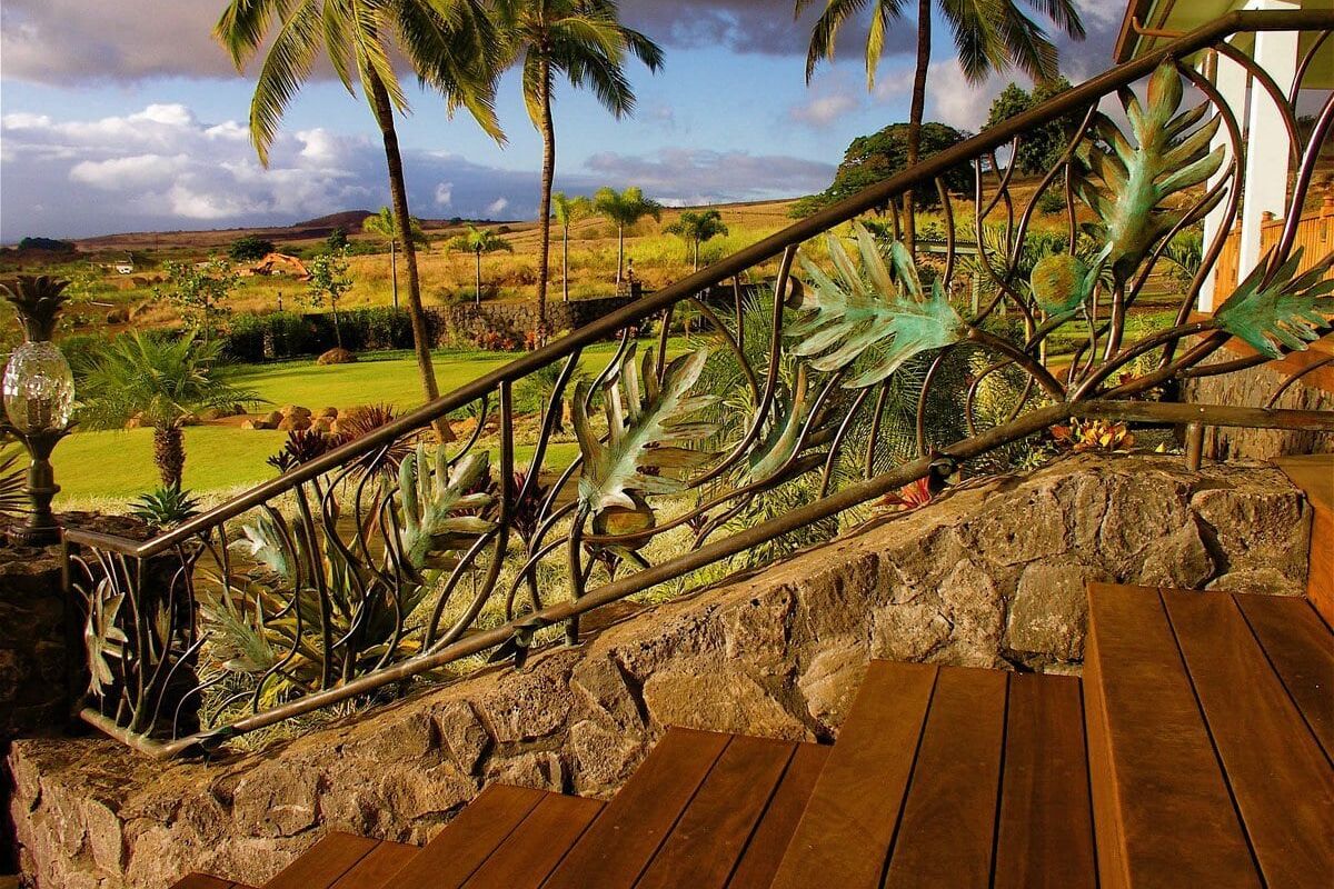 Tropical patio with wooden floor and palm trees in the background.