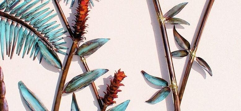 Artistic botanical wall decor with metal leaves and flowers.