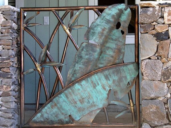 Artistic gate featuring a large butterfly wing design made of metal and stone.