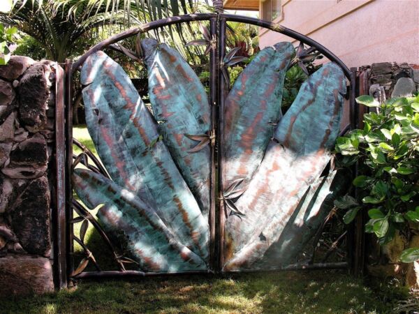Metal garden gate with painted fish artwork.