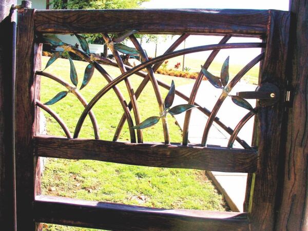 Wooden fence with artistic cut-out patterns against a sunny garden background.