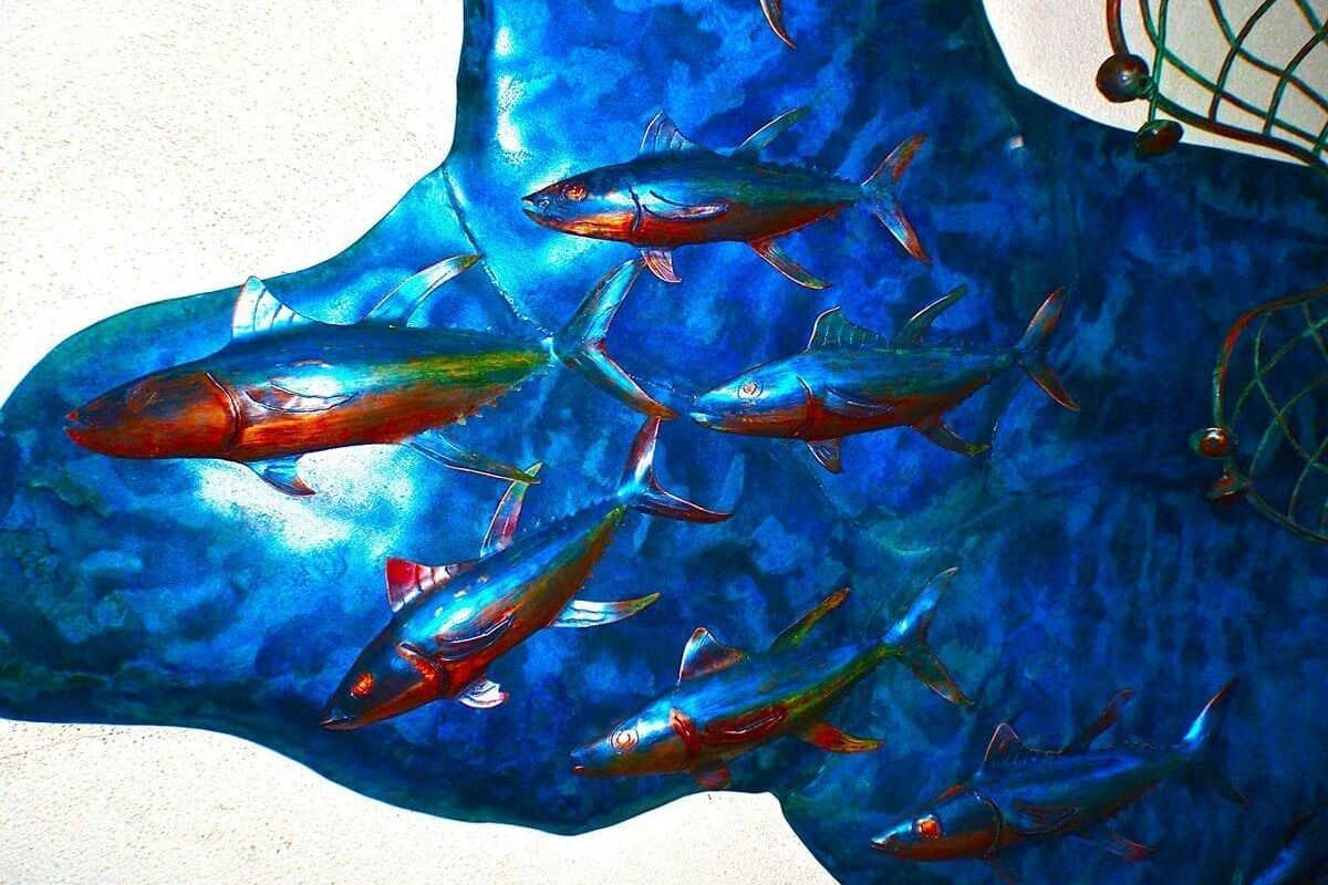 A school of small fish swimming in blue water.