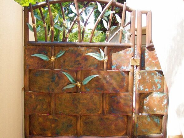 Rustic wooden gate with artistic carvings and metal accents.
