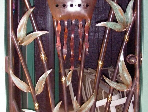 Decorative bamboo and metal wall art with a whimsical face design.