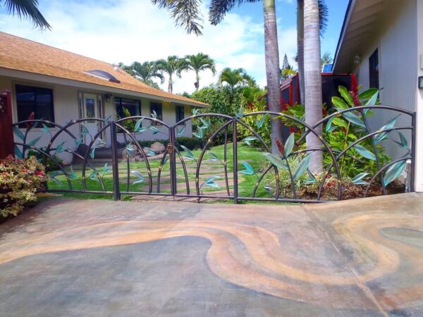Decorative metal fence with a tropical garden background.