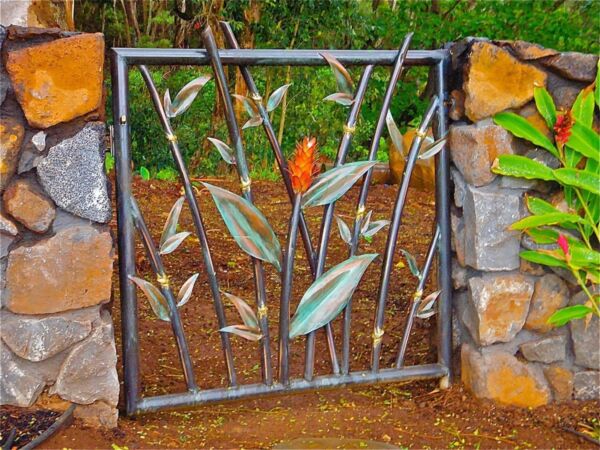 Decorative iron gate with leaf motifs set between stone pillars.