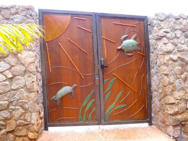 Rustic metal gate with turtle and dolphin designs.