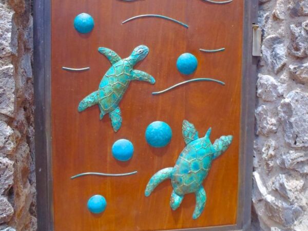 Door decorated with sea turtle carvings and blue dots.