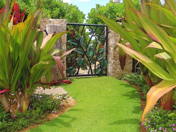 A lush garden pathway leading to a decorative gate.