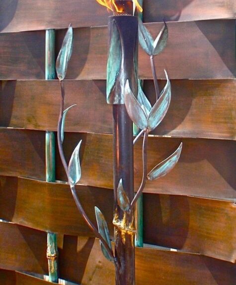 Artistic metal sculpture with abstract leaf designs on a wooden background.