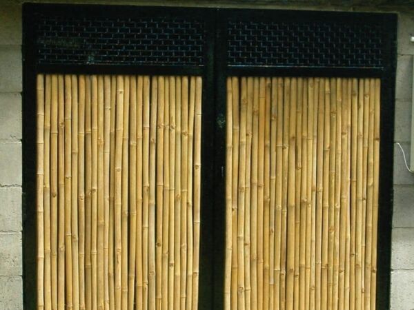 Sliding bamboo doors framed in black against a white wall.