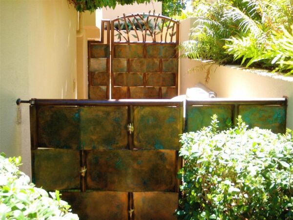 Stacked metal blocks outdoors with greenery in the background.