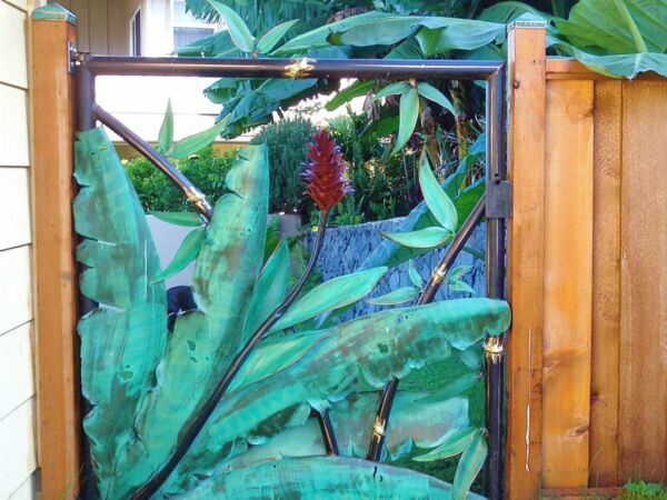Decorative garden gate with large green leaves design.