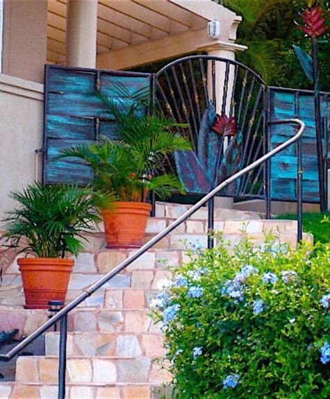 A stone staircase with potted plants and a decorative blue gate.
