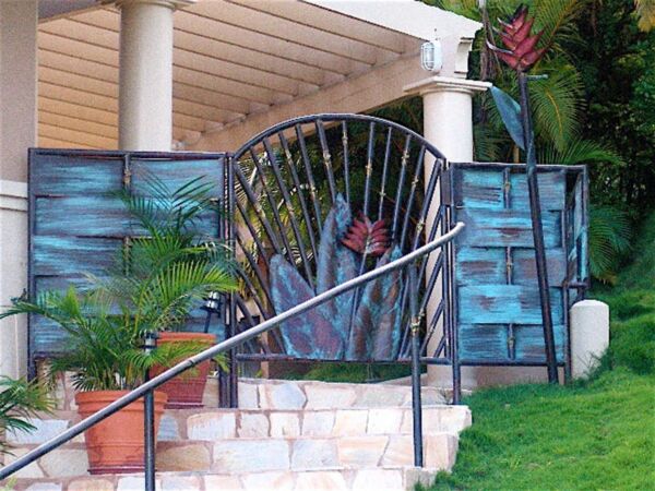 Person sitting behind a unique metal gate on stairs.