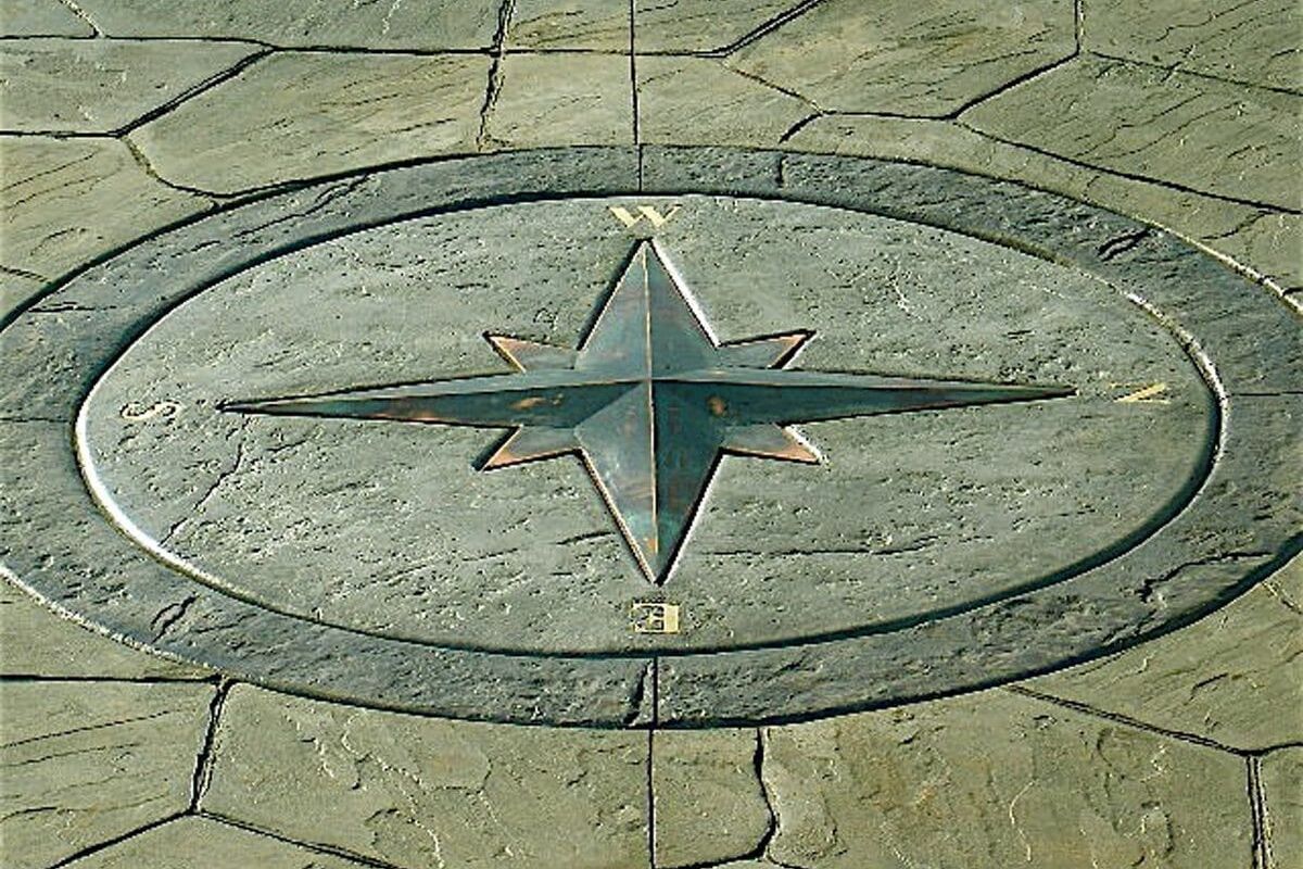 Stone compass rose embedded in paved ground.