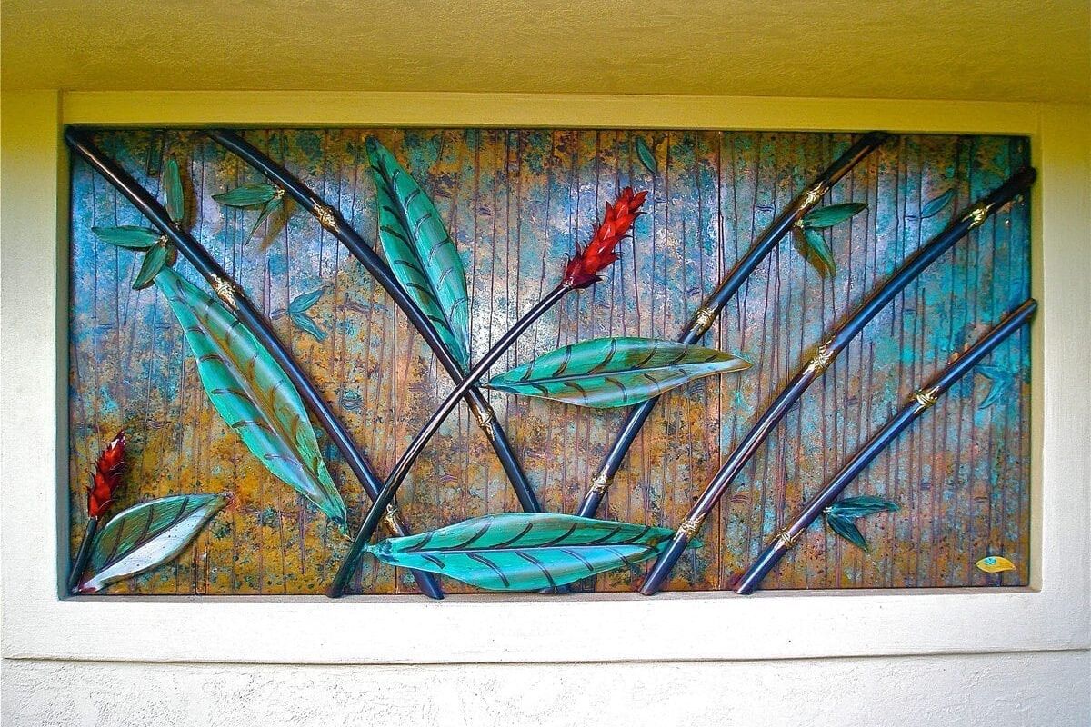 A colorful wall mosaic depicting green leaves and a red flower.