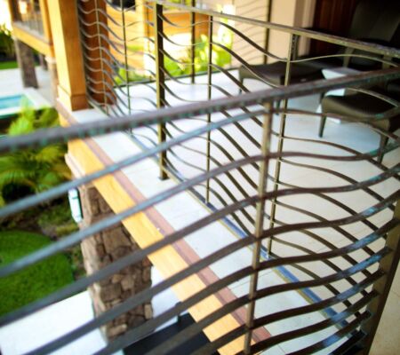 Curved metal railing with a modern design by a staircase.