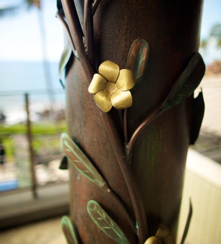 Close-up of a decorative brown vase with a gold flower accent.