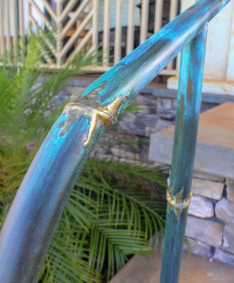 Close-up of a rusted and chipped blue metal railing outdoors.