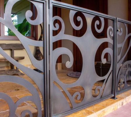 Decorative metal railing with artistic swirling patterns on a staircase.