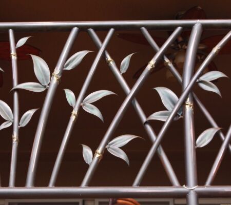 Decorative metal railing with leaf and branch design.
