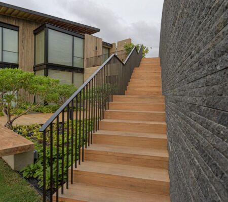 Outdoor staircase with black railing and modern landscaping.