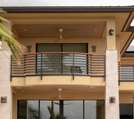 Modern balcony with metal railing and ceiling fan.