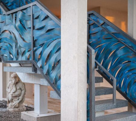 Blue abstract mural decorates stairwell walls in an indoor setting.
