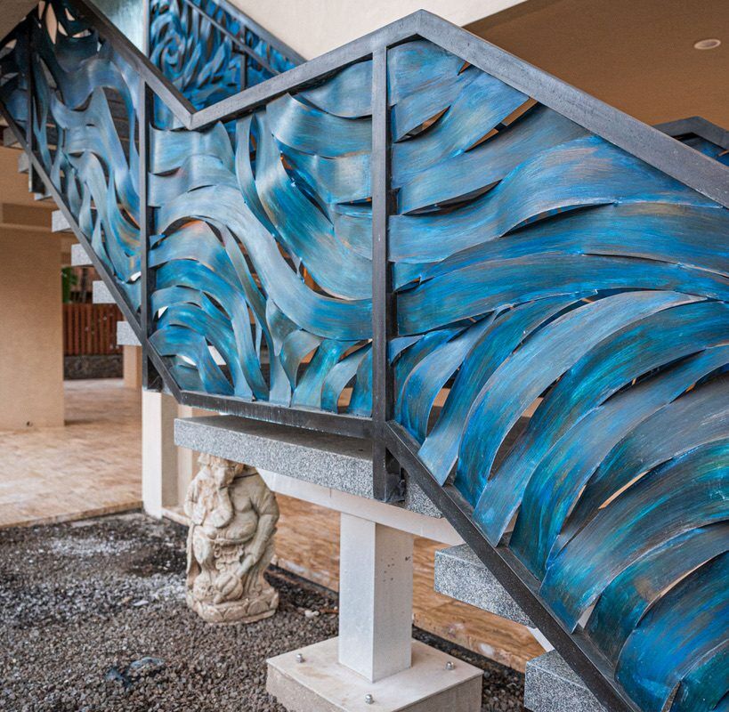 Blue abstract wave design on a glass railing indoors.